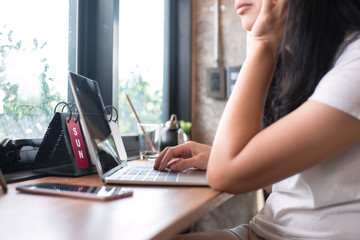 woman hand using laptop and cup of coffee her working on laptop in coffee shop, freelance lifestyle.