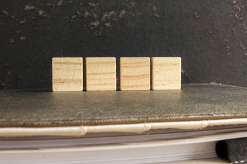 Blank wood scrabble pieces isolated on grunge black background.