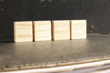 Blank wood scrabble pieces isolated on grunge black background.