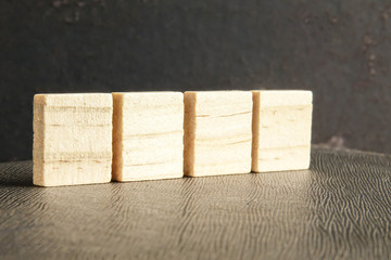 Blank wood scrabble pieces isolated on grunge black background.