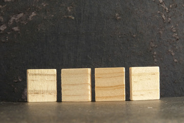 Blank wood scrabble pieces isolated on grunge black background.