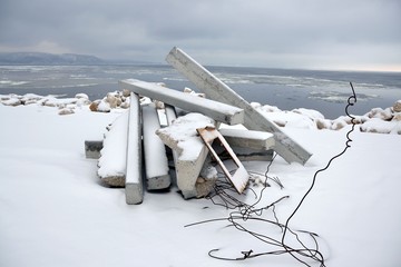The remains of construction waste on the background of the winter landscape