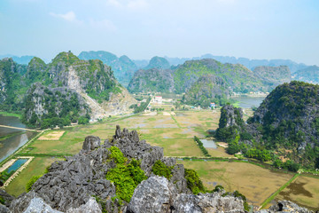 Hang Mua Mountain viewpoint or Mua Caves Ecolodge, Stunning view of Tam Coc area with mountain range, rice fields and waterway.