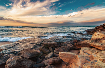 Seashore with cliffs, waves crashing on rocks