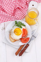 fried eggs on a piece of white bread and orange juice