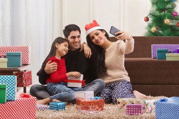 Happy family use Smart phone to take selfie on Christmas celebrations