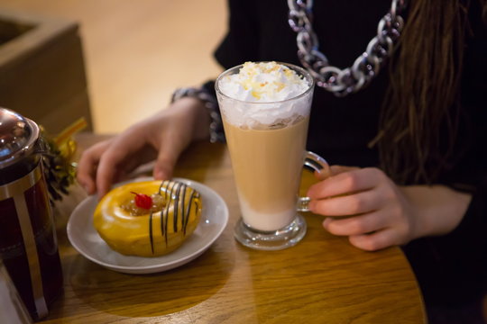 girl's hands holding a cup with laia and cake