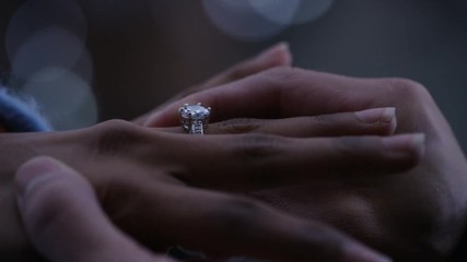 Male hand putting a ring on his partner's finger as he proposes, in slow motion