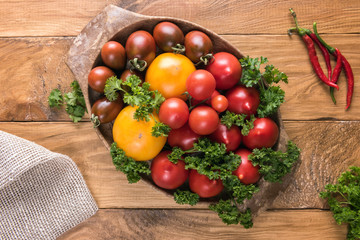 Assortment of fresh colorful tomatoes in oval bowl