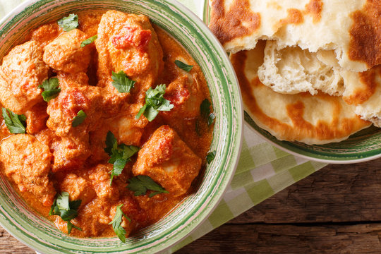 Karhai chicken in a spicy tomato sauce closeup served with naan. Horizontal top view