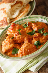 Karhai chicken in a spicy tomato sauce closeup served with naan. vertical