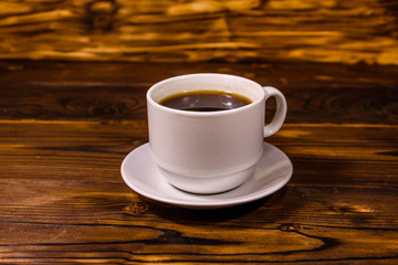 Cup of dark coffee on wooden table