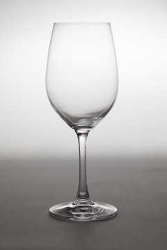 Glass wine glass stands on gray background