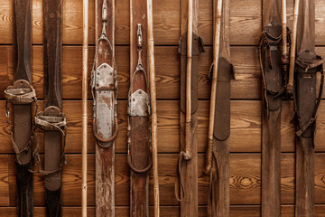 Collection of vintage wooden weathered skis. Winter sport vintage equipment on wooden wall....