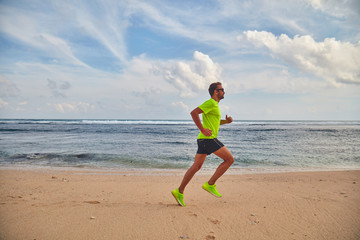 Man running / jogging on a tropical exotic beach.