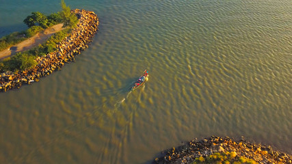 Traditional thail long-tail boat, floats and moves from the bay forward in the middle of the sea. Wooden motor boat floating in the water