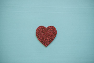 Obraz premium Red heart on a blue background. Concept for Valentine's Day or Women's Day or the topic of health, life, donation and help. In minimal style.