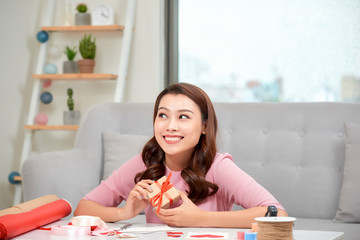  Happy young woman pressing gift box to her chest