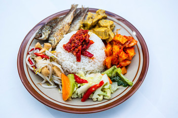 Indonesian style nasi campur with ikan goreng, gulai nangka, kentang balado, sayur capcay and tumis toge tahu