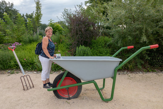 Frau mit riesiger Schiebetruhe im Garten von Tulln