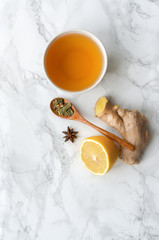 Obraz na płótnie Canvas Healthy beverage on marble table. Vertical photo. Lemon, ginger and spices tea. 