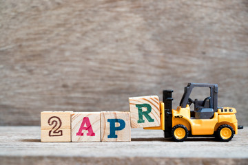 Toy forklift hold block R to complete word 2apr on wood background (Concept for calendar date 2 in month april)