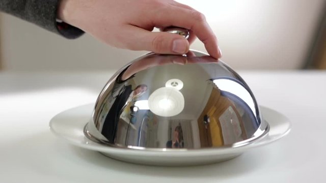 Waiter opens the empty dish
