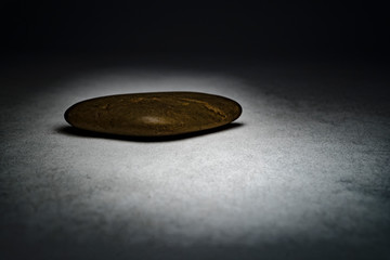 Rough pebble stones on the background of dirty concrete in the dark