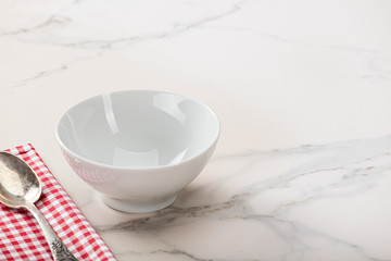 Soup bowl on marble background with plaid napkin