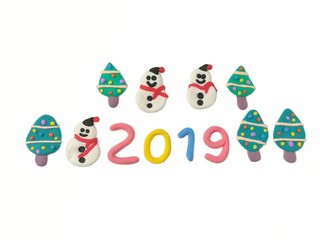 Cute snowman have sweet smile, colorful snow on tree and 2019 new year text made from plasticine clay are placed on white background, beautiful dough decorate are festival
