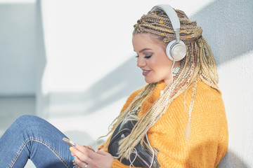 beautiful young girl chooses a song in a playlist, concept of listening to music with headphones