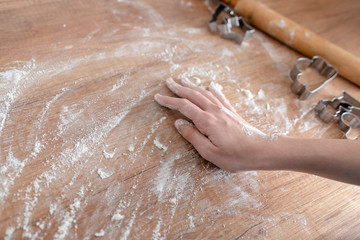Fototapeta premium Christmas cookies preparation. Cookies cutter, dough for cookies and rolling pin on the kitchen table. Homemade treats. Selective focus.