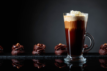  Chocolate dessert with hazelnut and coffee with cream on a black background.