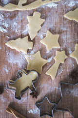 Christmas cookies preparation. Cookies cutter, dough for cookies and rolling pin on the kitchen table. Homemade treats. Selective focus.