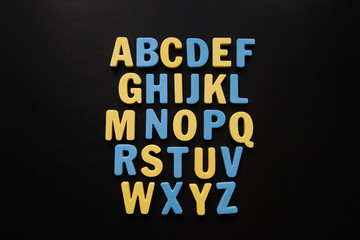alphabet on black background - obrazy, fototapety, plakaty