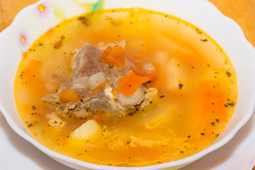 Shurpa - traditional mutton soup in Central Asia on a wooden background