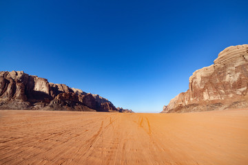 Fototapeta na wymiar Red Desert Landscape of Wadi Rum in Jordan, with a sunset, stones, mountains and the sky.