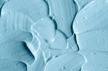 Blue cosmetic clay (facial mask, cream, body scrub) texture close up. Abstract background with brush strokes. 