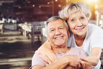 Happy senior couple smiling on background