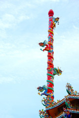 Dragon pillar in Chinese temple in Thailand with blue sky.