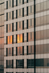 Sunset orange light reflected on glass and cladding facade in the evening.