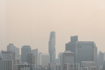 Fototapeta premium Air pollution effect made low visibility cityscape with haze and fog from dust in the air during sunset in Bangkok, Thailand.
