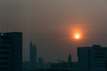 Fototapeta na wymiar Air pollution effect made low visibility cityscape with haze and fog from dust in the air during sunset in Bangkok, Thailand.