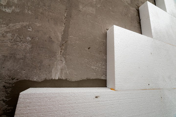Close-up detail of plastered house wall with rigid styrofoam insulation. Modern technology,...