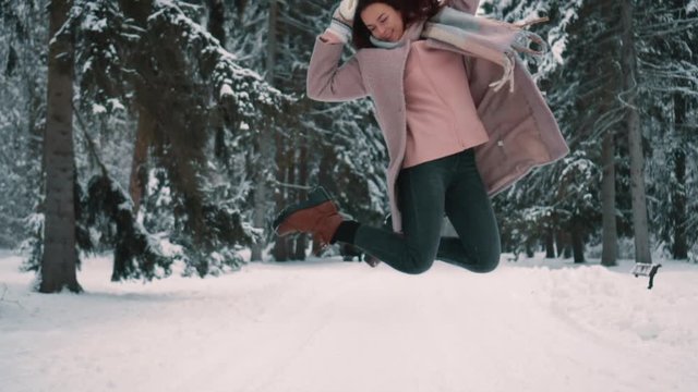 happy woman jumps up in twinter park
