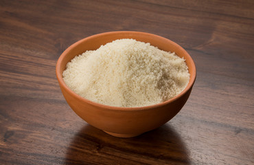 Fototapeta na wymiar Food: Raw Unrefined Cane Sugar in Earthen Bowl on Wooden Background Shot in Studio