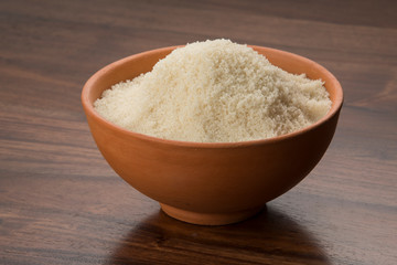 Food: Raw Unrefined Cane Sugar in Earthen Bowl on Wooden Background