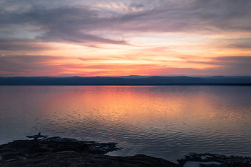Dead Sea - October 05, 2018: Tourists bathing in the salty Dead Sea by sunset, Jordan