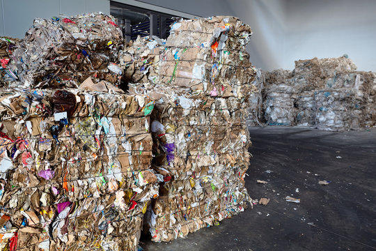 Used cardboard polyethylene and plastic pressed into bales at finished products warehouse on modern waste sorting and processing plant