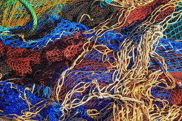 Fishing nets fill the screen in close-up. Colorful fishnet background